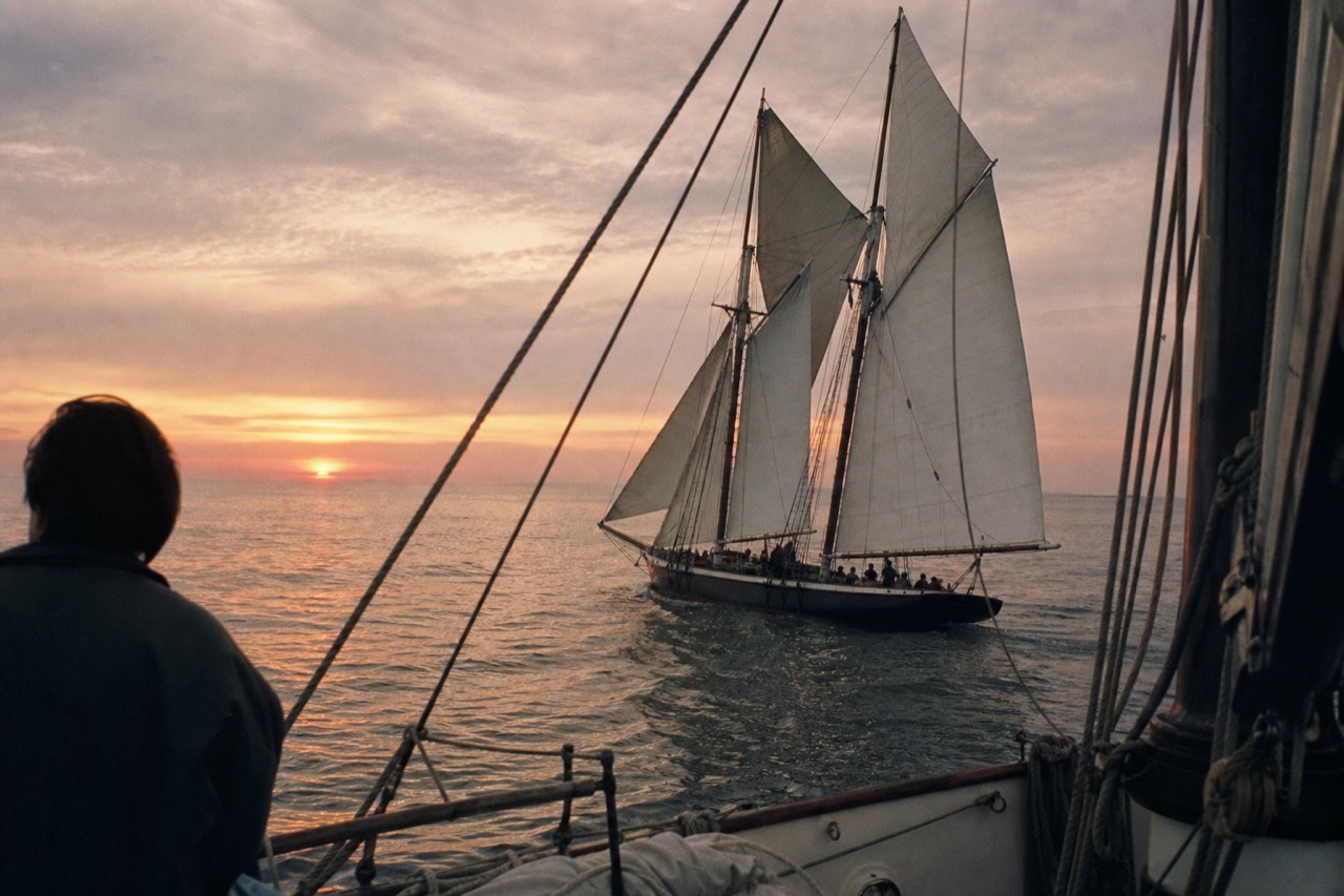 Schooner under full sail on golden water at sunset in Key West, no text, no logos, no people
