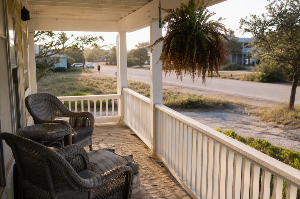 An empty Key West guesthouse porch in soft late-afternoon light, no text, no logos, no people