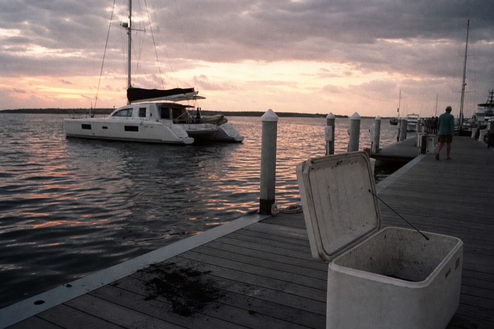 A catamaran at anchor near the Key West Historic Seaport at dusk, no text, no logos, no people