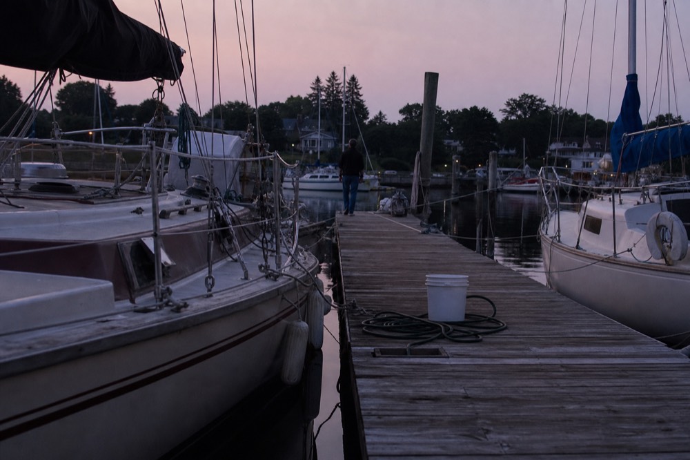 A quiet Key West harbor at dusk with boats moored along a wooden dock, no text, no logos, no people