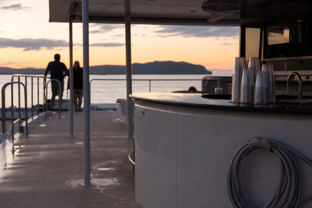 Open deck of a catamaran at dusk with calm water, no text, no logos, no people