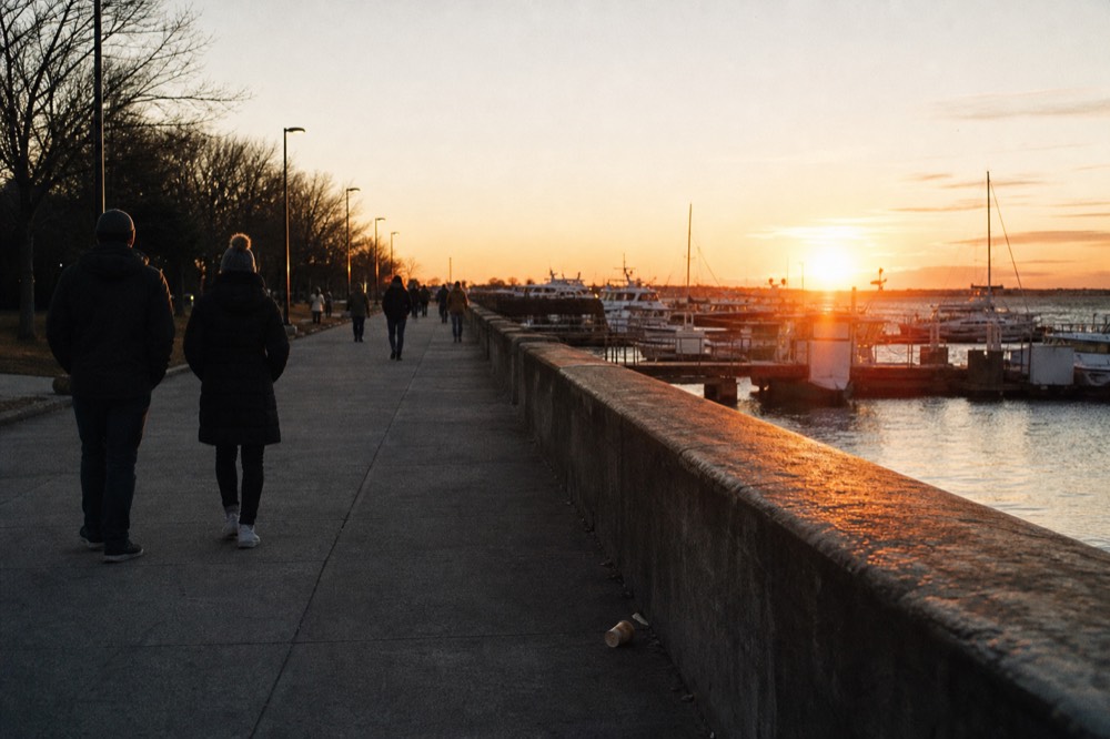 People walking along the waterfront at Mallory Square as the sun sets over the water, no text, no logos, no people