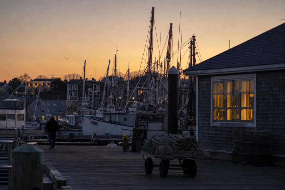 A wide view of the Key West skyline and masts at the Historic Seaport under a fading orange sky, no text, no logos, no people