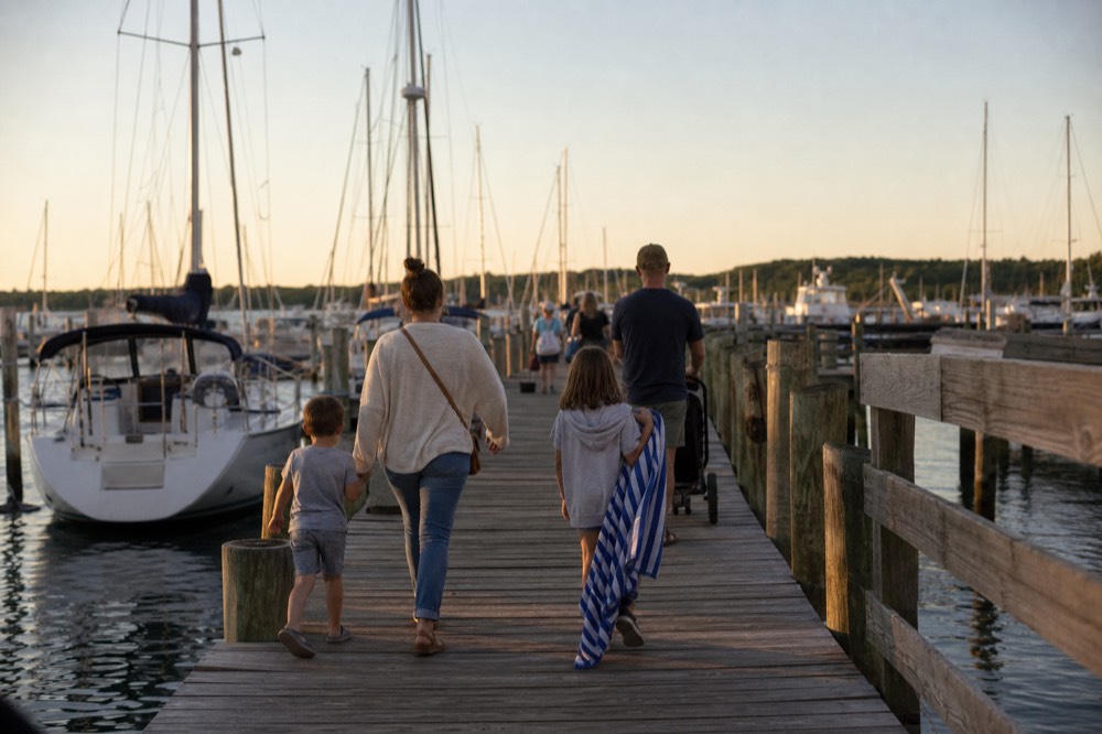 Families walking a wooden dock at the Key West Historic Seaport in golden evening light, no text, no logos, no people