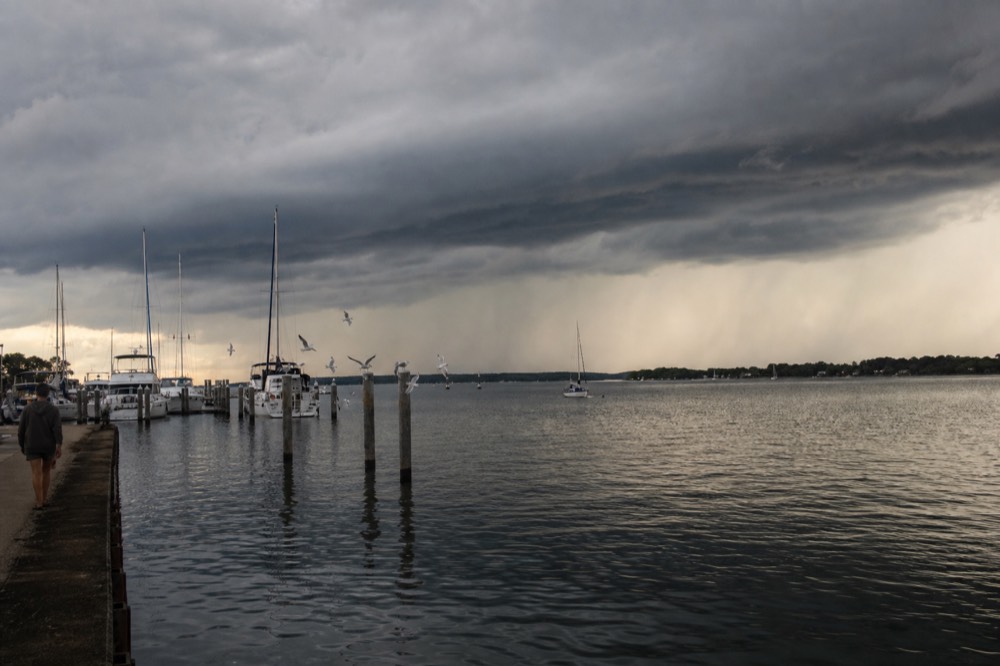 Dark storm clouds gathering over calm Key West water near a marina, no text, no logos, no people