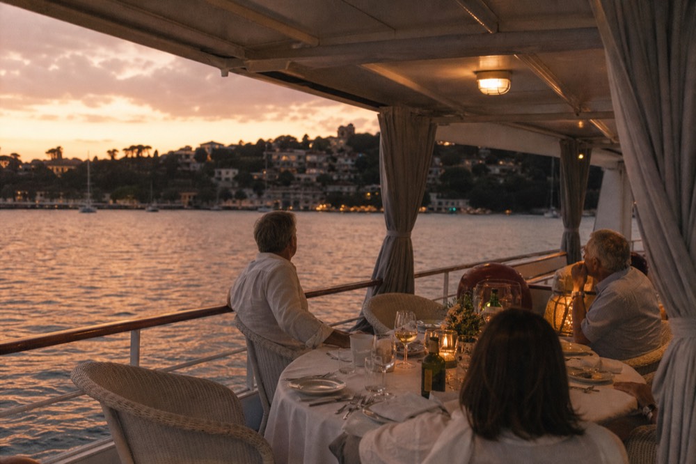 A covered dinner table on a boat deck with the Key West shoreline behind it at dusk, no text, no logos, no people.