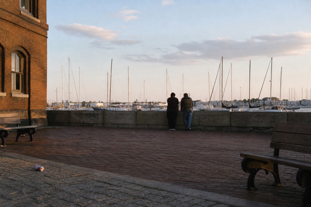 A historic Key West waterfront plaza at golden hour with old brick buildings and masts, no text, no logos, no people