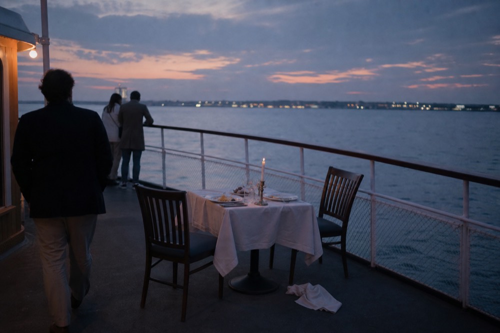 A couple's table set for dinner on a boat deck at dusk, no text, no logos, no people