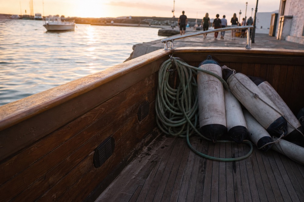 A quiet corner of a boat deck at golden hour with calm water beyond, no text, no logos, no people
